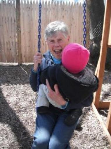 Phyl swings with child at shelter